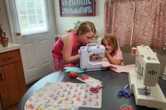 Helping her little cousin learn to sew